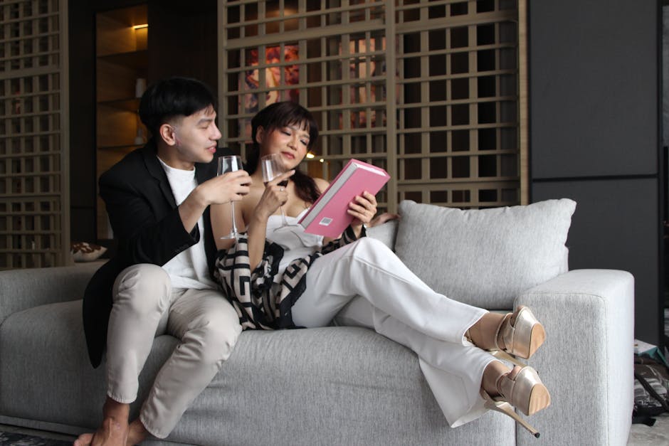 A couple enjoying wine and a book indoors, capturing a cozy and modern lifestyle.